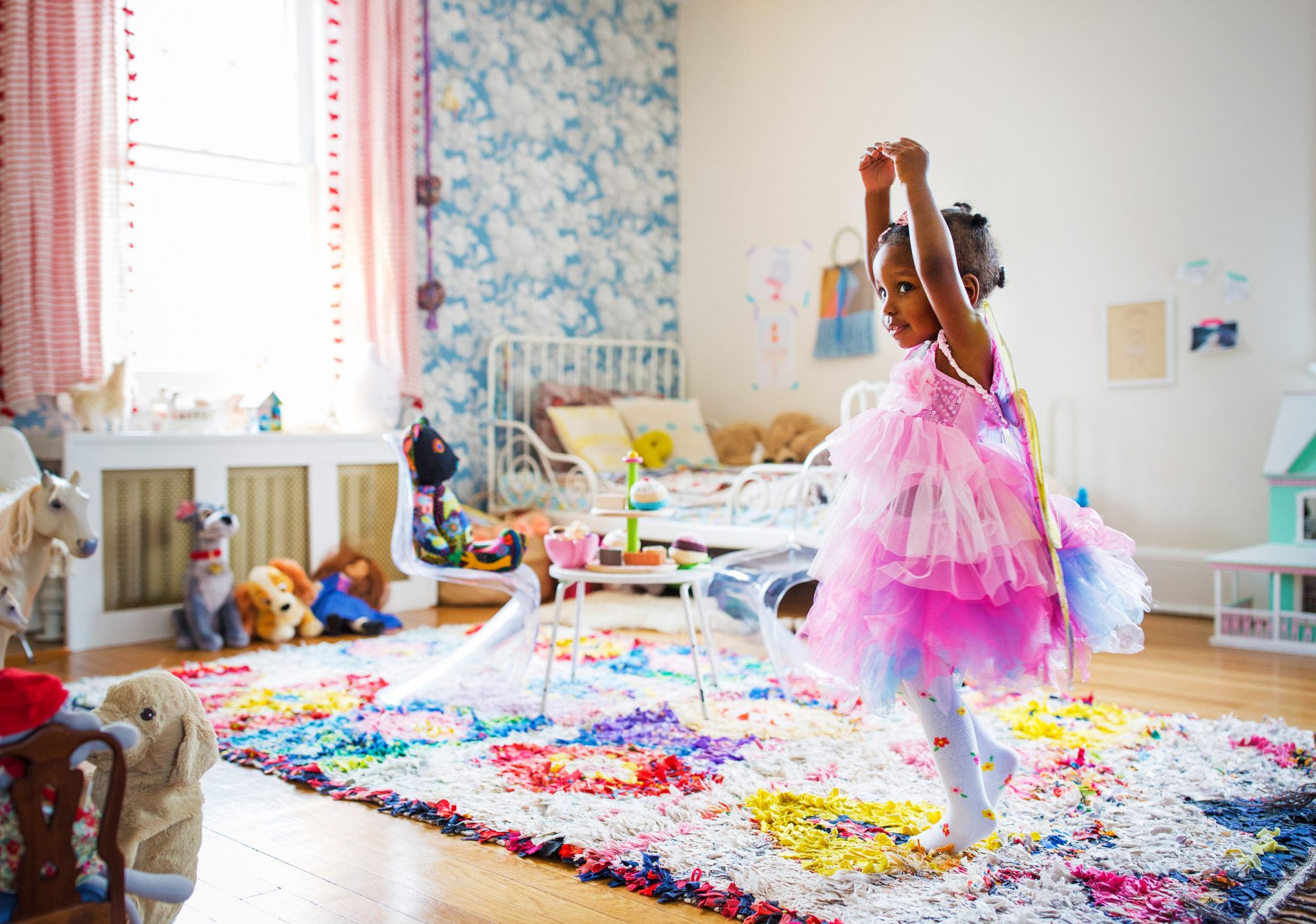 An image of a little girl dancing in her room.
