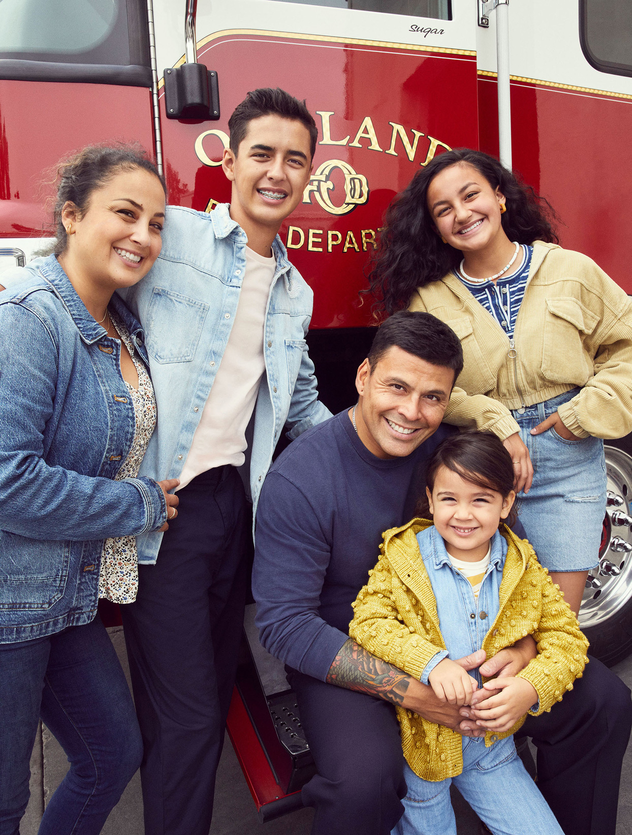 father and firefighter Luis Licea with family near firetruck