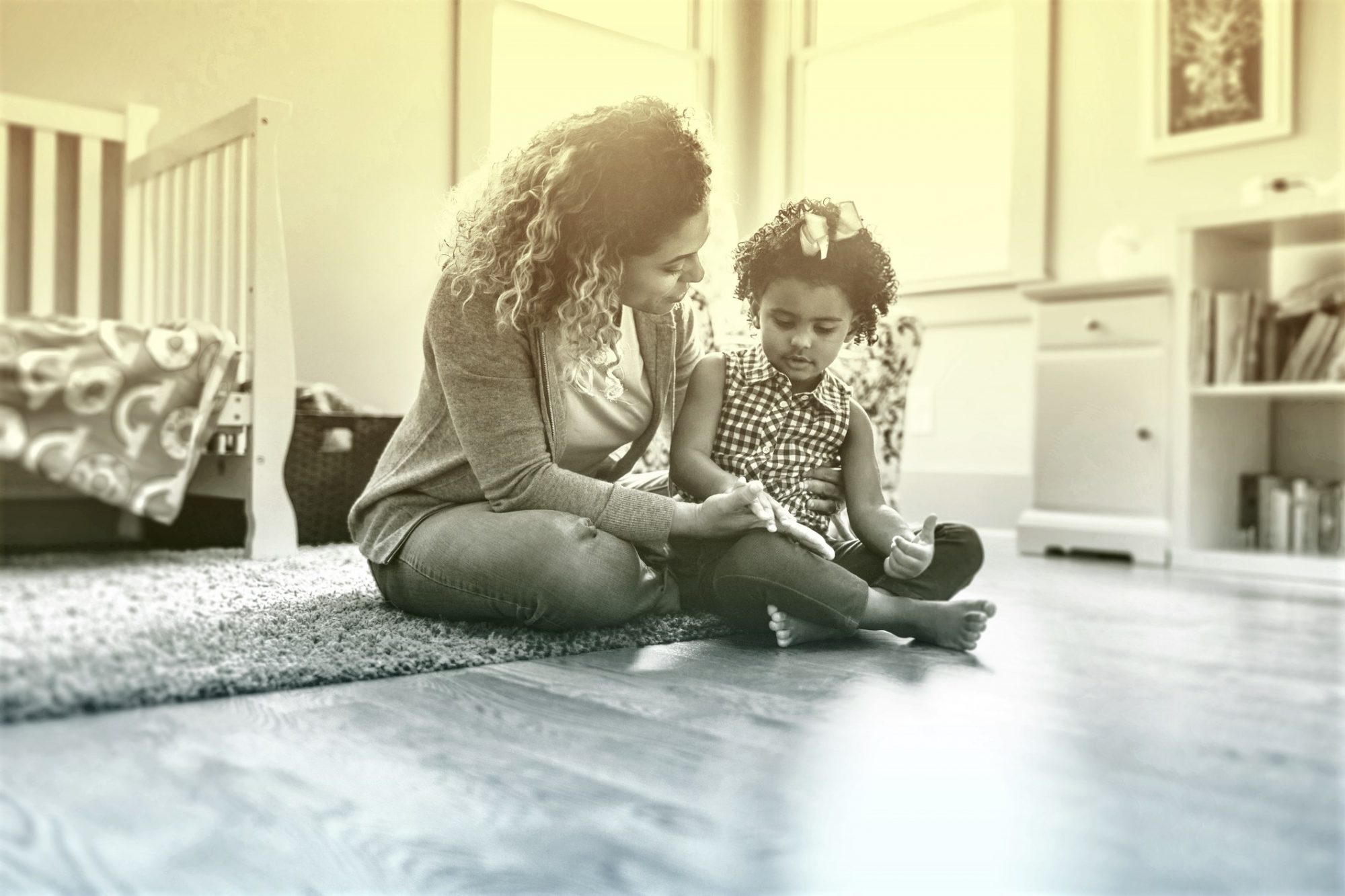 Mother and daughter playing on bedroom floor